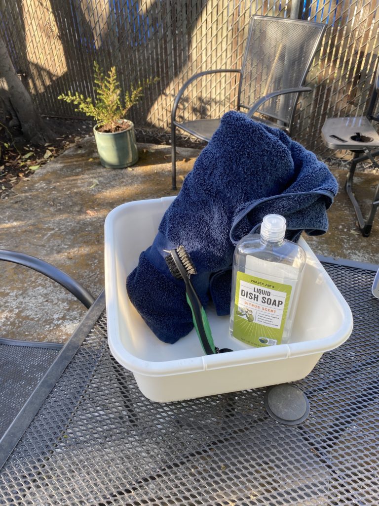 bucket, dish soap, brush and towel