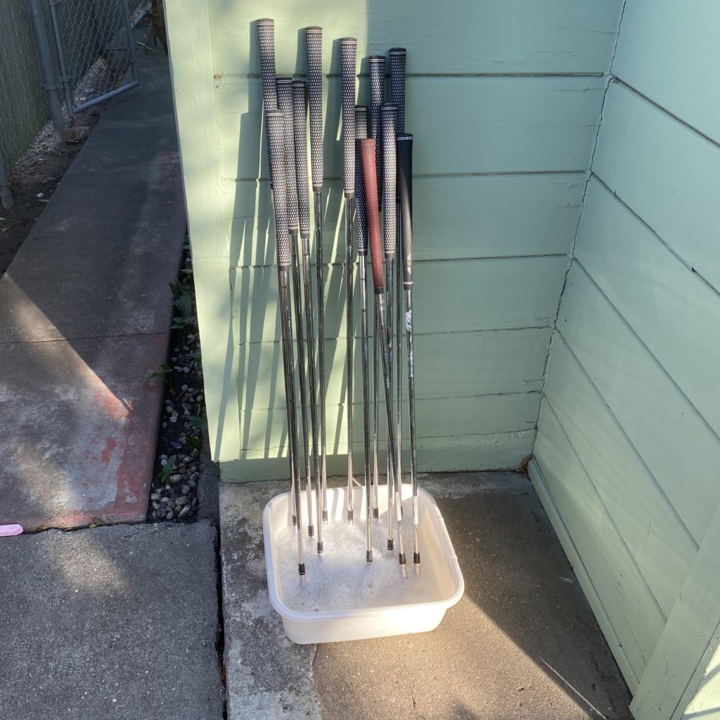 golf clubs soaking in soapy water