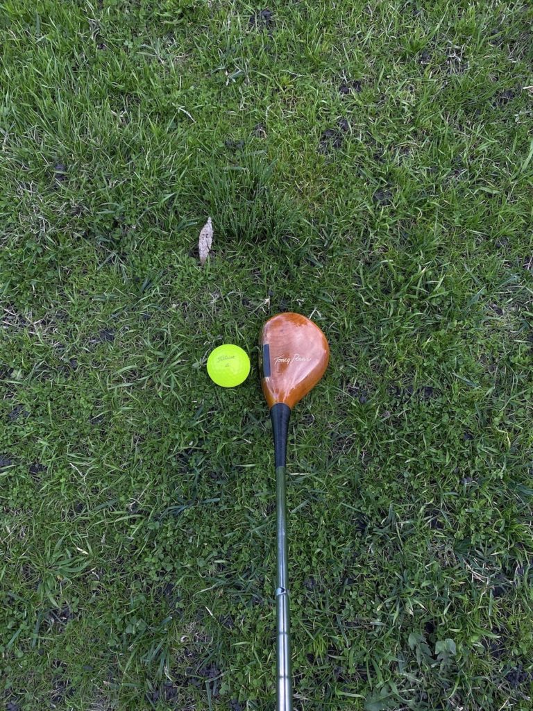 looking down at persimmon wood with golf ball