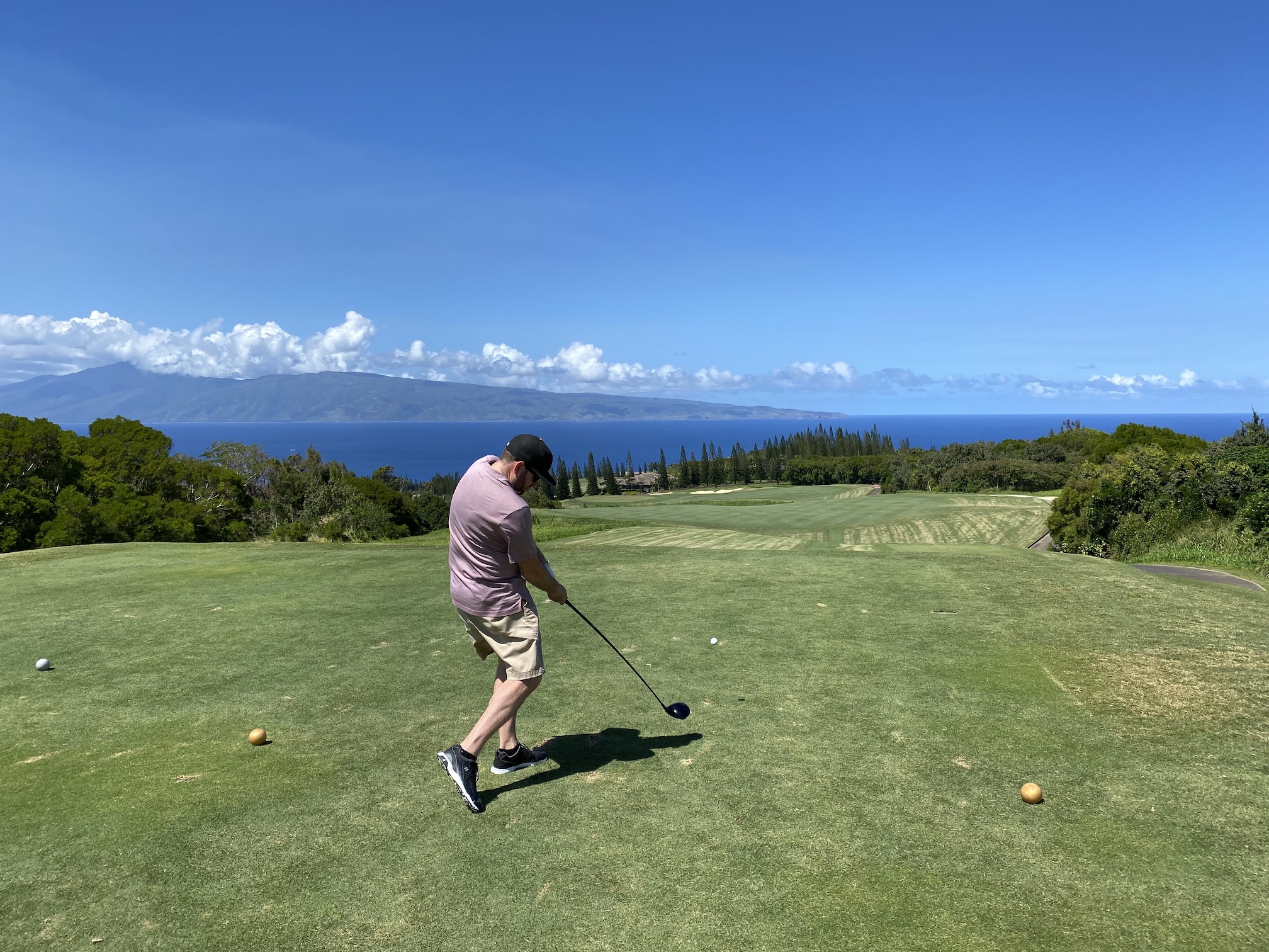 a man driving the ball with the ocean in the background